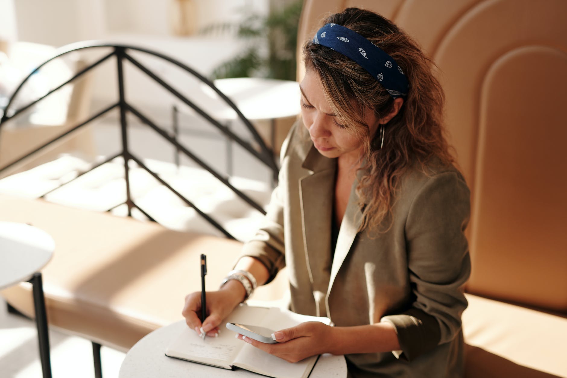 woman sitting at a table writing in a notebook