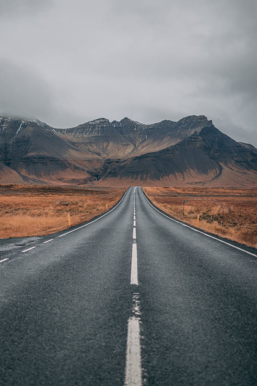 an empty road heading into the mountains